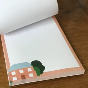 Petit bloc-notes illustré d'une maison rose, dos cartonné rigide
