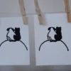 Linogravure noire et blanc d'un chat et un chien de dos se serrant